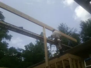 Carpenter setting a ridge beam over a new addition frame — Ice Dam Removal by Roofing Brothers in Pall Mall