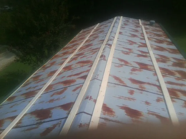 Rusted metal roof panels with new wood purlins before replacement — Storm Damage Roof Repair in Pall Mall by Roofing Brothers