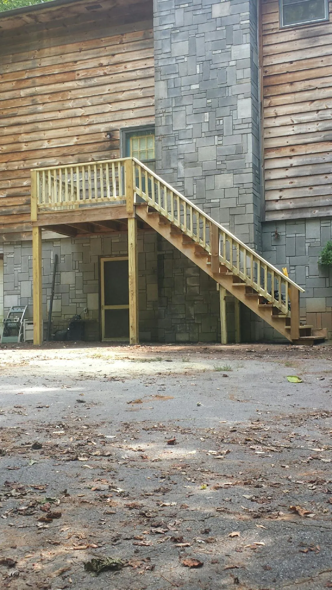 New pressure treated deck and stair landing on a log home in Pall Mall